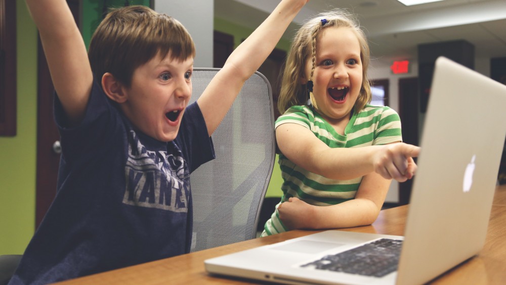 Deux enfants sont fous de joie devant un ordinateur qui affiche le blog de CityPanel